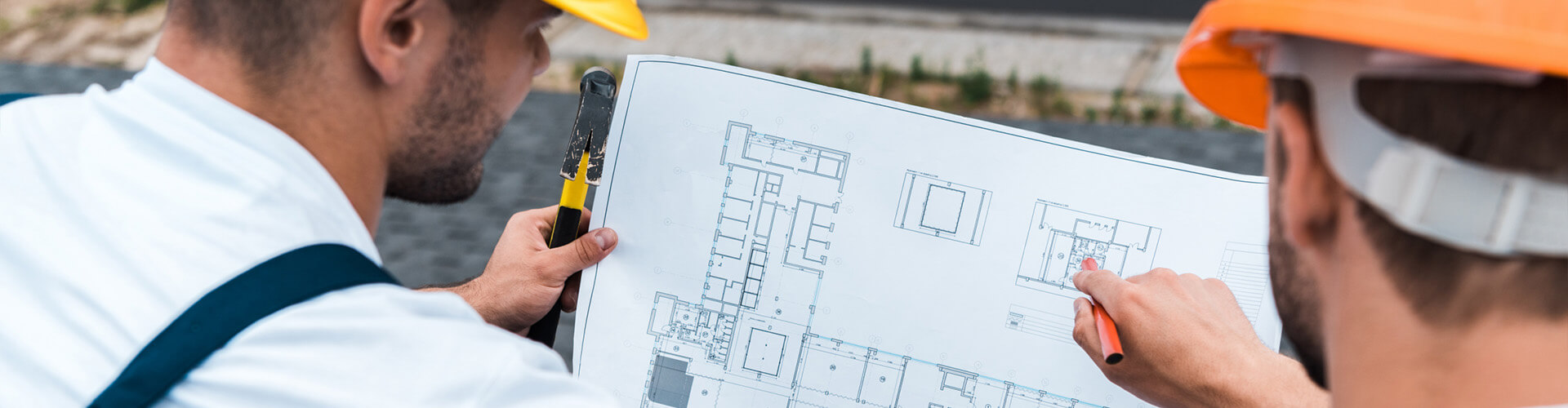Zwei Bauarbeiter schauen auf einen Gebäudeplan