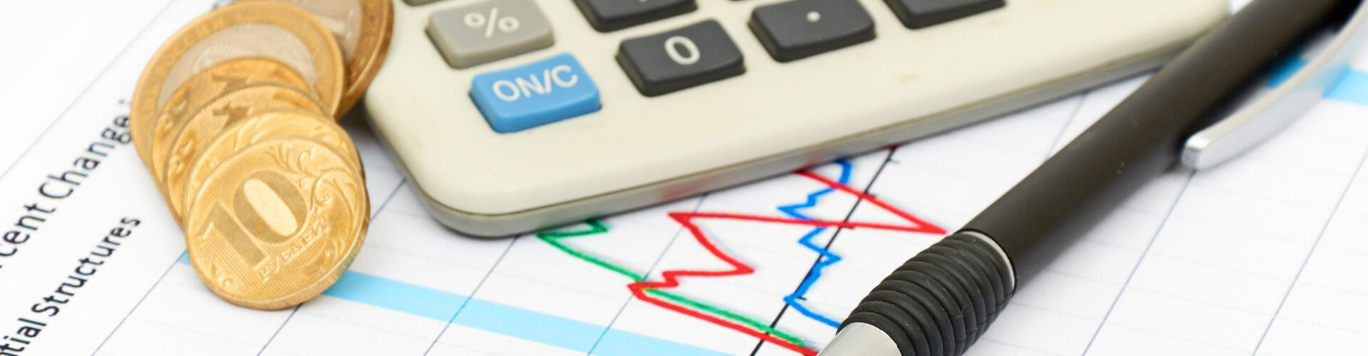 Statistik auf dem Geldstücke, ein Kugelschreiber und ein Taschenrechner liegen